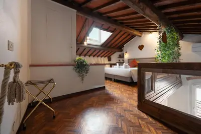 Letto o letti in una camera di Via Lamberti, 3 - Florence Charming Apartments - Charming and historic 5th-floor attic apartment with elevator in a building at the heart of vibrant Florence, just a 2-minute walk from all attractions